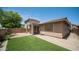 Backyard with artificial turf, desert landscaping, and a covered patio at 3439 W Darien Way, Phoenix, AZ 85086