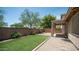 Well-maintained backyard with artificial turf, desert landscaping, and a covered patio at 3439 W Darien Way, Phoenix, AZ 85086