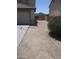 A view of the side of the home with a long driveway leading to a gate at 40504 N Las Praderas St, San Tan Valley, AZ 85140