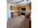 Well-lit kitchen featuring wooden cabinets and modern appliances, including a microwave and oven at 40504 N Las Praderas St, San Tan Valley, AZ 85140