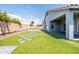Wide shot of the artificial turf backyard with stone paver accents and covered patio at 4140 E Claxton Ave, Gilbert, AZ 85297