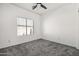 Cozy bedroom offers a window with natural light, a ceiling fan and neutral carpeting at 4140 E Claxton Ave, Gilbert, AZ 85297