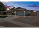 Well-maintained home exterior with paved driveway and manicured landscaping at twilight at 4140 E Claxton Ave, Gilbert, AZ 85297