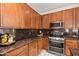 Close up of kitchen with wood cabinetry, stainless appliances, granite counters, and stylish decor at 4140 E Claxton Ave, Gilbert, AZ 85297
