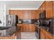 Kitchen with wood cabinets, stainless appliances, granite countertops, and views of the open concept living space at 4140 E Claxton Ave, Gilbert, AZ 85297