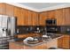 Close up of kitchen with wood cabinetry, stainless appliances, granite counters, kitchen island, and stylish decor at 4140 E Claxton Ave, Gilbert, AZ 85297