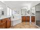 Bright main bathroom with dual sinks, soaking tub, tile floors, and mirrored closet at 4140 E Claxton Ave, Gilbert, AZ 85297