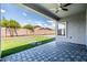 View of the covered patio with ceiling fan overlooking the artificial turf with paver accents at 4140 E Claxton Ave, Gilbert, AZ 85297