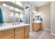 Bright bathroom with dual sinks, light wood cabinetry, tile floors, and a separate door for privacy at 4630 E Navigator Ln, Phoenix, AZ 85050