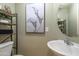 Stylish powder room with round mirror, decorative wall art, and a convenient shelving unit next to the toilet at 4743 E Laurel Ave, Gilbert, AZ 85234