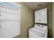 Well-lit laundry area with a modern washer and dryer set, complemented by upper cabinets and natural light at 4743 E Laurel Ave, Gilbert, AZ 85234