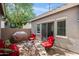 Cozy patio with outdoor furniture, including a grill, red cushioned seating, and a small table, perfect for relaxing at 4743 E Laurel Ave, Gilbert, AZ 85234