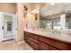 A bathroom featuring a double vanity, a large mirror, and an abundance of natural light at 5861 E Anderson Dr, Scottsdale, AZ 85254