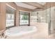 Bright bathroom features a large soaking tub with a view and a glass enclosed shower at 5861 E Anderson Dr, Scottsdale, AZ 85254