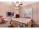 This bedroom features a ceiling fan, rocking chair and window with shutter at 5861 E Anderson Dr, Scottsdale, AZ 85254