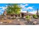 Single-story home with desert landscaping, rocks, and a mature shade tree at 5861 E Anderson Dr, Scottsdale, AZ 85254