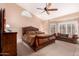 A large main bedroom with a ceiling fan and a sitting area with a couch at 5861 E Anderson Dr, Scottsdale, AZ 85254