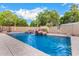 Backyard pool features a rock waterfall feature and lush landscaping at 5861 E Anderson Dr, Scottsdale, AZ 85254