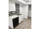 Stylish kitchen with white cabinets, updated countertops, stainless steel sink, and modern star-patterned tile backsplash at 5975 N 48Th Dr, Glendale, AZ 85301