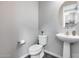 Elegant powder room featuring a pedestal sink, round mirror, and neutral color scheme, creating a serene space at 631 W Winchester Dr, Chandler, AZ 85286