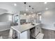 Bright, modern kitchen features an island with quartz countertops, pendant lighting, and stainless steel appliances at 631 W Winchester Dr, Chandler, AZ 85286