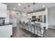 Open-concept kitchen features an island with bar seating, stainless steel appliances, and white cabinetry at 631 W Winchester Dr, Chandler, AZ 85286