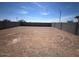 Large, unfinished backyard with dirt and a perimeter block wall under a clear blue sky at 640 S Maricopa Rd, Florence, AZ 85132