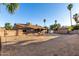 Expansive backyard with a covered patio, privacy wall, and gravel groundcover under a clear blue sky at 6424 E Aire Libre Ln, Scottsdale, AZ 85254