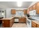 Eat-in kitchen with white appliances, wood cabinets, and tile flooring at 6424 E Aire Libre Ln, Scottsdale, AZ 85254