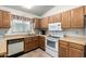 Traditional kitchen featuring wooden cabinetry, tile floors, and white appliances at 6424 E Aire Libre Ln, Scottsdale, AZ 85254