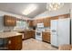 Bright eat-in kitchen with white appliances, wood cabinets, and tile flooring at 6424 E Aire Libre Ln, Scottsdale, AZ 85254