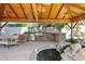 Covered patio featuring an outdoor kitchen, built-in grill, and pond with a waterfall feature at 6428 W Eugie Ave, Glendale, AZ 85304