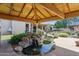 Serene backyard with a pond, rock waterfall, lush greenery, and a covered outdoor living area at 6428 W Eugie Ave, Glendale, AZ 85304