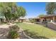 Expansive backyard featuring lush green lawn, mature trees, covered patio, and a charming gazebo at 6428 W Eugie Ave, Glendale, AZ 85304