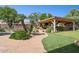 Beautiful backyard with a stone pathway, putting green, covered patio, and lush landscaping at 6428 W Eugie Ave, Glendale, AZ 85304