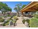 Lush backyard oasis featuring a pond, stone pathway, and covered patio with a fireplace and seating at 6428 W Eugie Ave, Glendale, AZ 85304