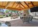 Covered patio with stone fireplace, outdoor seating, and a built-in grill overlooking the backyard at 6428 W Eugie Ave, Glendale, AZ 85304
