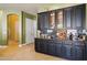 Elegant bar area with dark cabinetry, granite countertops, and ample storage for beverages at 6428 W Eugie Ave, Glendale, AZ 85304