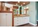 Bathroom with white cabinets, tile countertop, and mirrors at 6428 W Eugie Ave, Glendale, AZ 85304