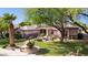 Single-story home with mature trees, green lawn, desert landscaping, and covered front entry at 6428 W Eugie Ave, Glendale, AZ 85304