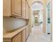 Bright hallway with custom cabinets, travertine floors, and archways leading to other rooms at 6428 W Eugie Ave, Glendale, AZ 85304