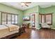 Large main bedroom with hardwood floors, a ceiling fan, and multiple windows with shutters at 6428 W Eugie Ave, Glendale, AZ 85304