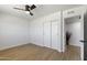 Bright bedroom with hardwood floors, ceiling fan, and closet space, perfect for relaxation and storage at 6723 E 1St Ave, Scottsdale, AZ 85251