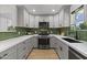 Modern kitchen featuring sleek cabinetry, stainless steel appliances, and stylish backsplash at 6723 E 1St Ave, Scottsdale, AZ 85251