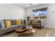 Cozy living room with stylish furniture, a jute rug, and a large window, creating a comfortable and inviting space at 6723 E 1St Ave, Scottsdale, AZ 85251