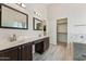 Elegant bathroom with double sinks, large mirrors, and a walk-in closet with shelving at 719 W Milada Dr, Phoenix, AZ 85041