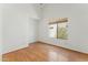 An empty bedroom with hardwood floors and natural light from the window at 719 W Milada Dr, Phoenix, AZ 85041