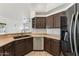 Well-lit kitchen featuring stainless steel appliances, dark wood cabinetry, and a double sink at 719 W Milada Dr, Phoenix, AZ 85041