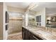 Elegant bathroom featuring double sinks with granite countertops, a tiled shower, and ample storage at 7510 E Larkspur Dr, Scottsdale, AZ 85260