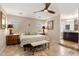 Cozy main bedroom featuring stone floors, a ceiling fan, and an ensuite bathroom for added convenience at 7510 E Larkspur Dr, Scottsdale, AZ 85260